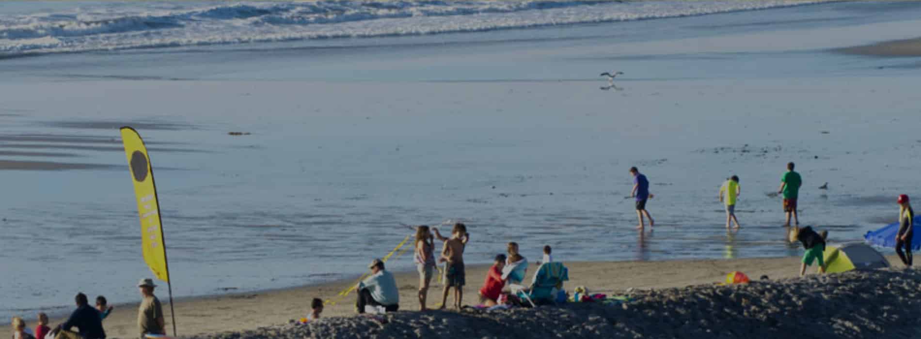 Families swimming and fishing at Moonlight State Beach in Encinitas San Diego. Discover homes for sale opportunities with the best real estate agents