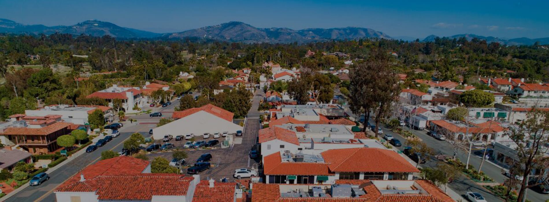 Aerial view of Rancho Santa Fe town in California with parked cars lining the streets.