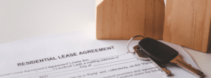 A close-up of a lease agreement with keys next to it.