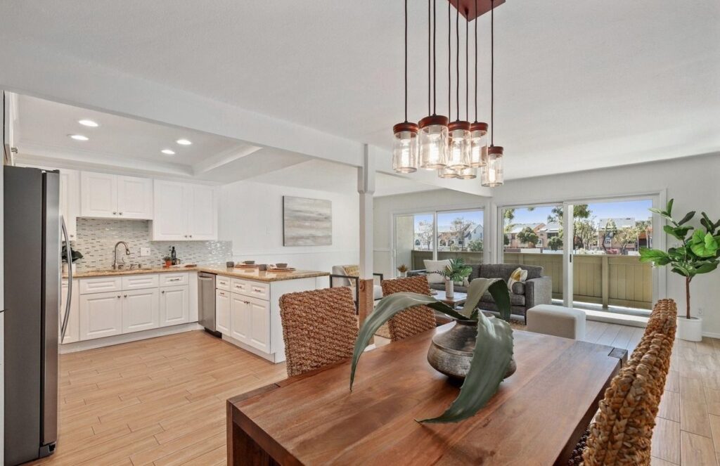 A cozy kitchen with a dining table and chairs, part of a charming 2-bedroom condo in Carlsbad, San Diego. Perfect for rent!