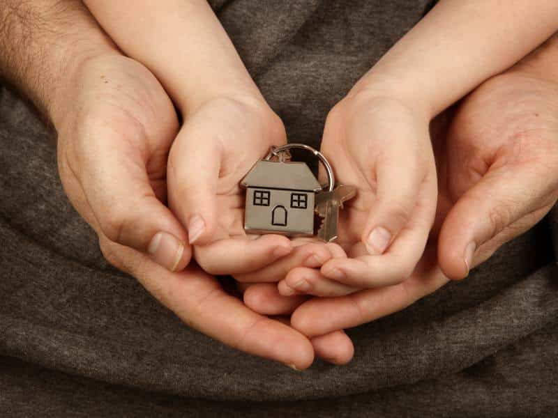 A man holding a house key in his hands, symbolizing access to Section 8 housing assistance program.