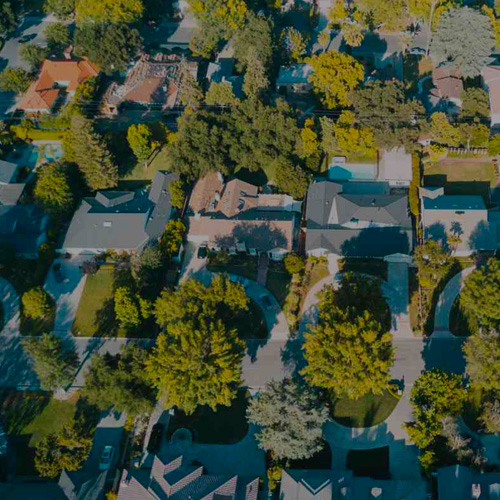 Aerial view showcasing a residential neighborhood in Central Escondido CA, featuring houses, streets, and greenery.