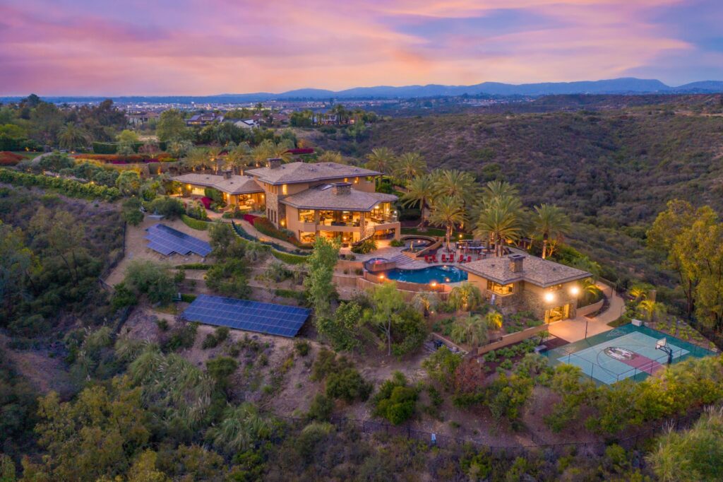 Aerial view of a hillside home in Del Mar, CA, showcasing the scenic landscape and property management features.