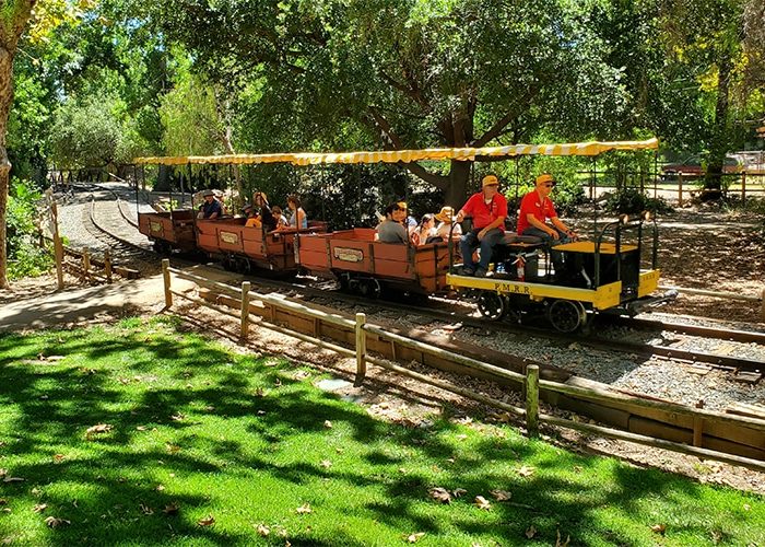 People taking a ride on the vintage steam train through the Old Poway Park. Discover homes for sale opportunities with the best real estate agents in San Diego.