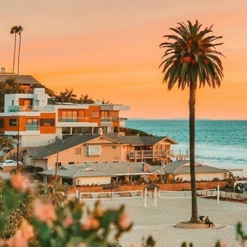 A beach house with palm trees and a beach at sunset in Encinitas community, San Diego.