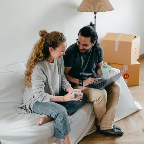 Image of a woman and a property management agent on a couch with a laptop