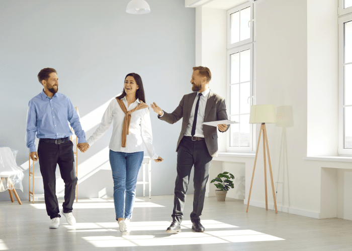 Three individuals walking in a vacant room during evictions in California.