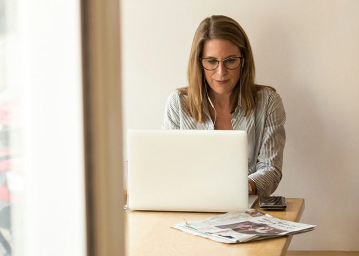 A woman sitting at a desk with a laptop, efficiently managing her property with professional management services.